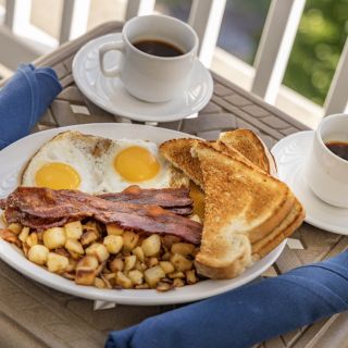 A full breakfast including hash browns, eggs, coffee, and toast