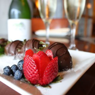 A plate of chocolate-covered strawberries and champagne