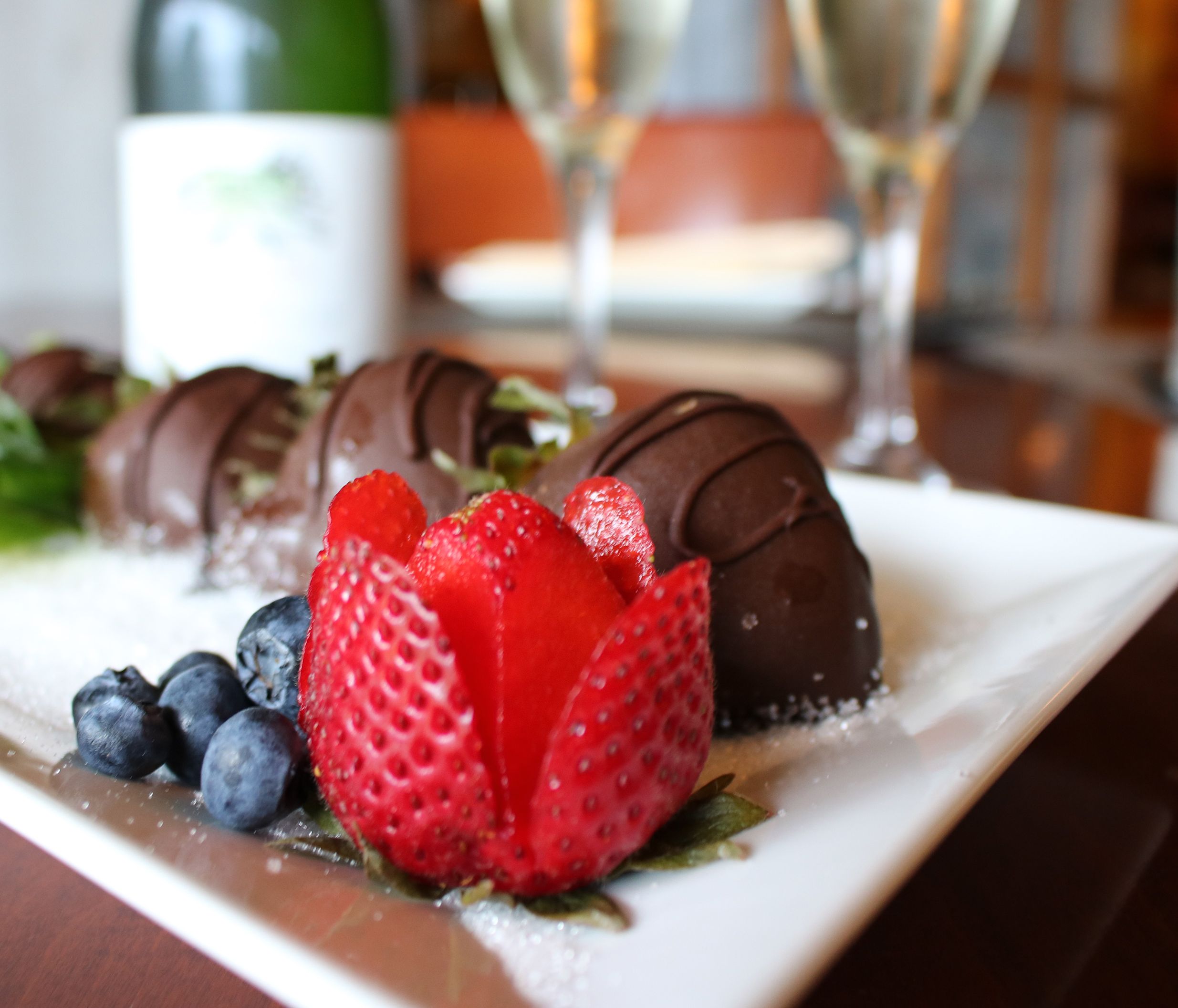 A plate of chocolate-covered strawberries and champagne