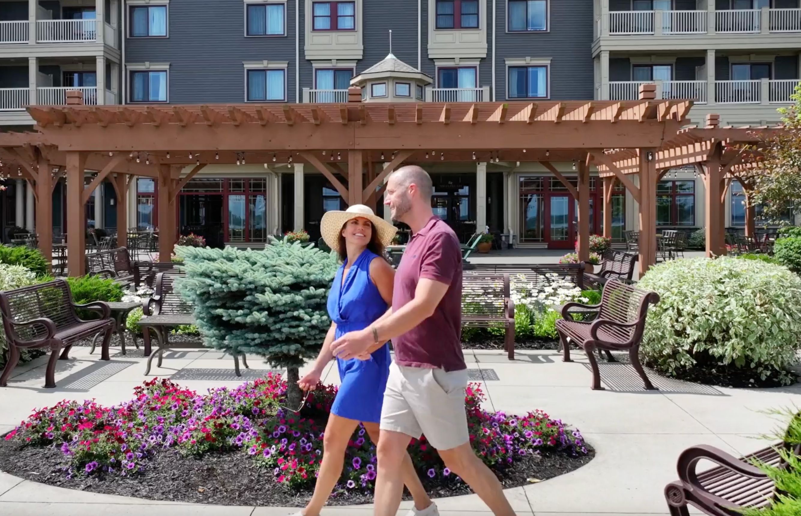 A couple walks on the beautifully manicured grounds of the 1000 Islands Harbor Hotel
